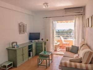 ein Wohnzimmer mit einem Sofa und einem TV in der Unterkunft Apartment Voramar-4 by Interhome in Calpe