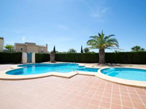una piscina con 2 palmeras en un patio en Holiday Home Yona by Interhome, en Empedrola
