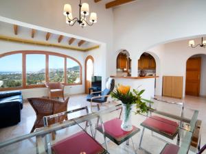 Una sala de estar con una mesa de cristal y sillas. en Holiday Home Yona by Interhome, en Empedrola