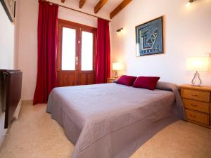 a bedroom with a large bed with red curtains at Holiday Home Yona by Interhome in Empedrola +16 photos