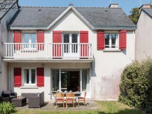a house with red shutters and a table and chairs at Holiday Home Les Marines by Interhome in Carnac-Plage