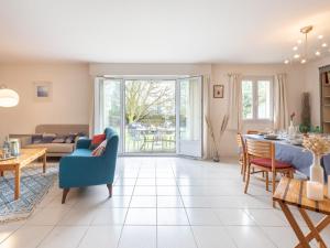 a living room with a blue chair and a table at Holiday Home Les Marines by Interhome in Carnac-Plage
