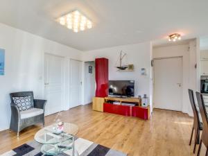 uma sala de estar com uma mesa e uma televisão em Apartment Clos Schuman by Interhome em Saint Malo