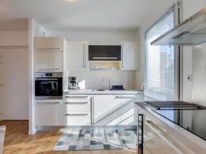 una cocina con armarios blancos y fregadero en Apartment Clos Schuman by Interhome, en Saint-Malo