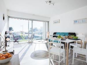 a white living room with a table and a dining room at Apartment La Cormorane-3 by Interhome in Carnac