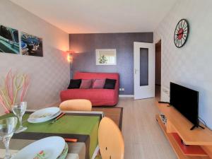 een woonkamer met een bank en een tafel bij Apartment Les Jardins de la Malouine by Interhome in Dinard