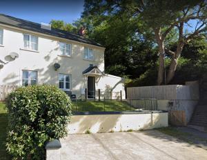 una casa blanca con una valla delante en Peaceful Home in Central Saundersfoot with Parking en Pembrokeshire