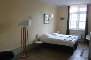Un dormitorio con una cama y una lámpara. en Manoir de la Dune, en Quend