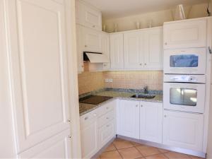 a white kitchen with white cabinets and a sink at Apartment Le Panoramic by Interhome in Sainte-Maxime