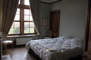 a bedroom with a bed and a large window at Manoir de la Dune in Quend
