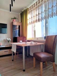 a dining room table with two chairs and a window at Uroczy Loft in Częstochowa