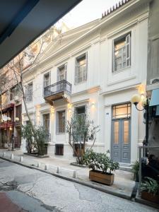 雅典的住宿－When in Athens Hostel，一条城市街道上的白色大建筑
