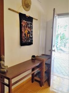 um quarto com um banco e uma pintura na parede em La Maison des Bambous Siem Reap em Siem Reap