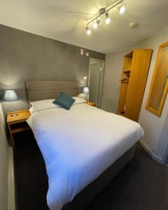 1 cama blanca grande en una habitación pequeña en Tollemache Arms en Calveley