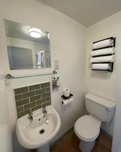 uma casa de banho com um WC branco e um lavatório. em Tollemache Arms em Calveley