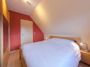 MispelburgにあるApartment Tivoli Gardens-4 by Interhomeの白いベッドと赤い壁のベッドルーム1室