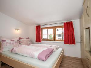 a bedroom with a bed with red curtains and a window at Apartment Gamsblick by Interhome in Sölden