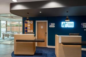 an office with a blue wall with a sign on it at Holiday Inn Express Cambridge West - Cambourne, an IHG Hotel in Cambridge