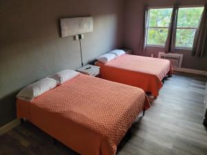 um quarto de hotel com duas camas e uma janela em Travel Inn Fort Pierce em Fort Pierce