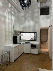 uma cozinha com armários brancos, um lavatório e um lustre em CASA ENEKO em Sevilha