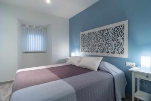 a bedroom with a bed with a blue wall at Estudio 19 Bajo reformado in Zamora