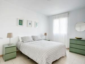 ein weißes Schlafzimmer mit einem Bett und zwei Nachttischen in der Unterkunft Apartment Pueblo del Cid-2 by Interhome in Molinell
