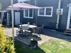 a patio with a table and an umbrella at Ferienhaus Ankerplatz in Bedekaspel +12 photos