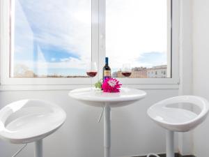 エンプリアブラバにあるApartment Port Mistral by Interhomeの白いテーブル(ワイン2杯、花付)