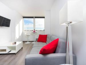 sala de estar con sofá gris y almohadas rojas en Apartment Port Mistral by Interhome, en Empuriabrava