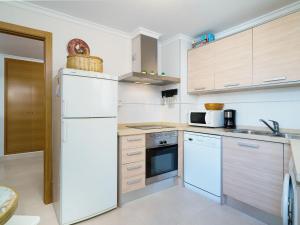 a kitchen with white appliances and wooden cabinets at Apartment Nova Soberana by Interhome in Jávea