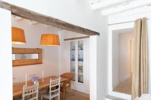a dining room with white walls and a wooden table and chairs at Casa da Avó Pam in Alcáçovas +39 photos