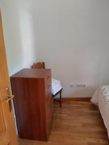CASAMAMPODRE في Maraña: غرفة نوم مع خزانة خشبية بجوار سرير