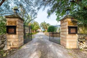 an entrance to a driveway with a wrought iron gate at Finca Hotel Rural Predio Son Serra in Can Picafort