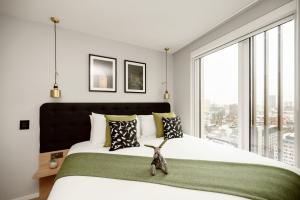 um quarto com uma cama grande e um urso de peluche. em Wilde Aparthotels Manchester St. Peters Square em Manchester