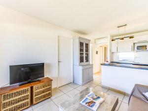 a living room with a tv and a kitchen at Apartment Arius by Interhome in Cavalaire-sur-Mer