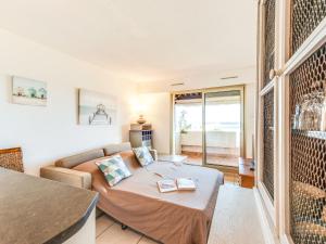a bedroom with a bed and a couch in a room at Apartment Arius by Interhome in Cavalaire-sur-Mer