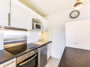 a kitchen with a sink and a clock on the wall at Apartment Arius by Interhome in Cavalaire-sur-Mer +18 photos