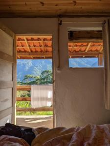 a bedroom with a bed and a window with a view at Solar Picu Eco-hospedaria in Itamonte