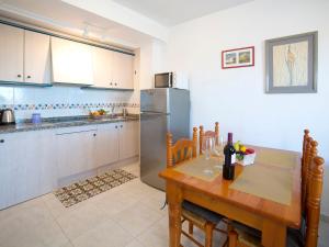 una cucina con tavolo in legno e frigorifero di Apartment Turquesa Beach-5 by Interhome a Calpe