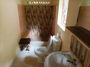 a bathroom with a toilet and a sink and a shower at Onja Surf Camp in Mahambo