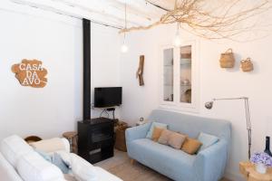 a living room with a blue couch and a tv at Casa da Avó Pam in Alcáçovas