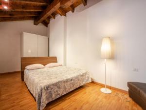 a bedroom with a bed and a lamp and a couch at Apartment Isola by Interhome in Orta San Giulio