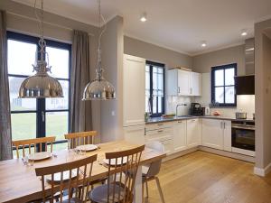 a kitchen and dining room with a table and chairs at Reetland am Meer - Superior Reetdachvilla mit 2 Schlafzimmern F02 in Dranske