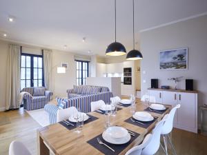 德蘭斯克的住宿－Reetland am Meer - Luxus Reetdachvilla mit 3 Schlafzimmern, Sauna und Kamin F15，用餐室以及带桌椅的起居室。
