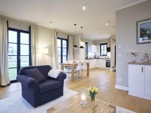 sala de estar con sofá azul y mesa en Reetland am Meer - Superior Reetdachvilla mit 2 Schlafzimmern F16, en Dranske