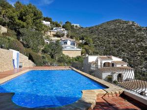 a large blue swimming pool in front of a house at Apartment La Colina by Interhome in Rada de Moraira