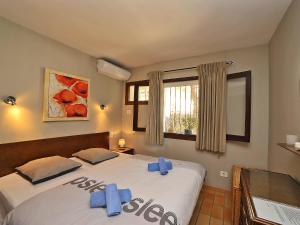 two beds in a bedroom with blue bows on them at Apartment La Colina by Interhome in Rada de Moraira
