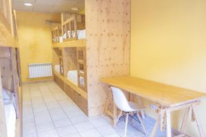 a room with a table and chairs and bunk beds at La Rectoria d'Albanyà in Albanya