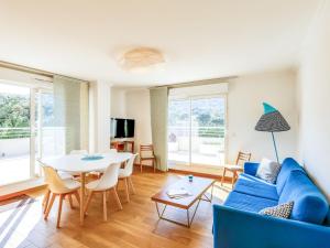 ein Wohnzimmer mit einem blauen Sofa und einem Tisch in der Unterkunft Apartment Cap Marine-3 by Interhome in Cavalaire-sur-Mer