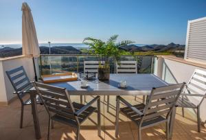 聖胡安德洛斯特洛斯的住宿－Mundo de sol golf et plage，阳台上配有蓝色的桌椅